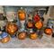 This is a group of carved gourd characters. They all have happy faces carved into the shells. They are lit up with battery-operated candles